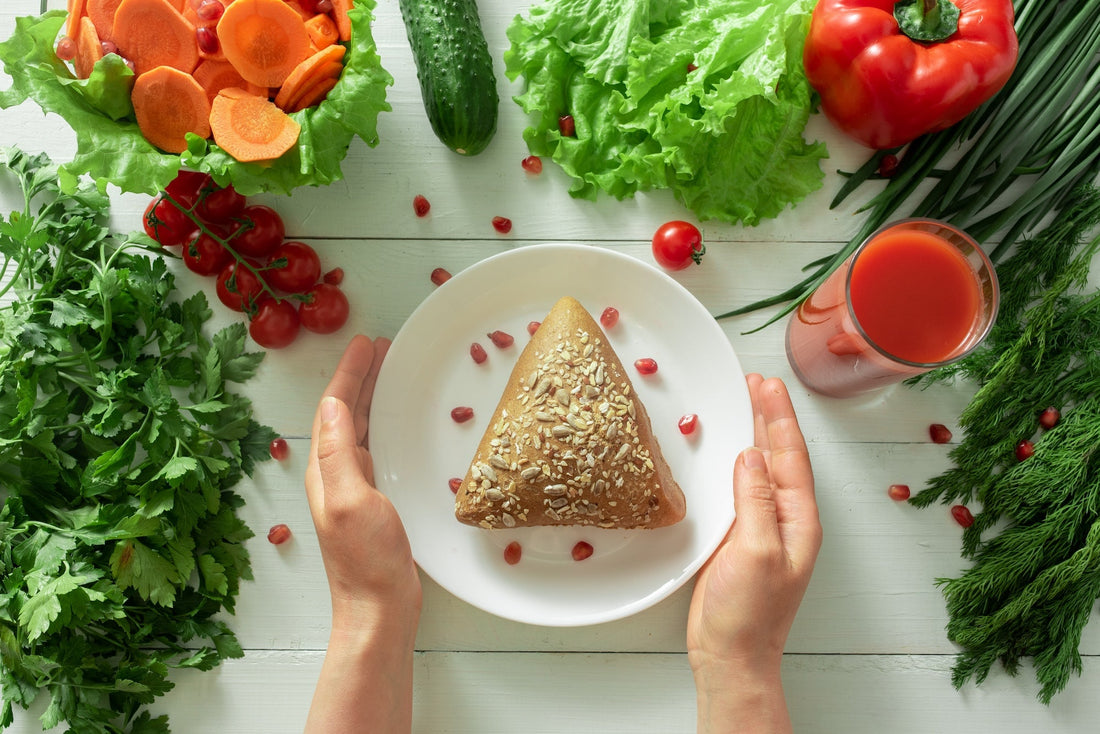 a platter of vegetables and a plate with a bread bun