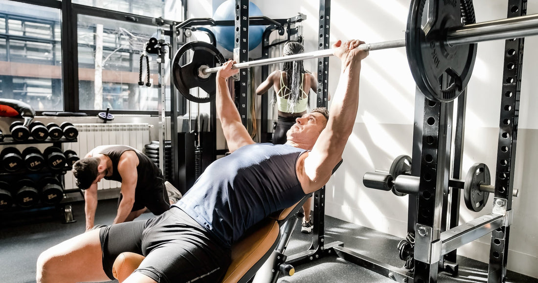 a man using a benchpress in a gym next to a window