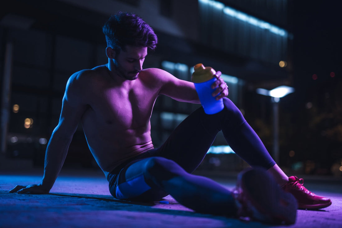 a man in purple lightning taking a break at the gym