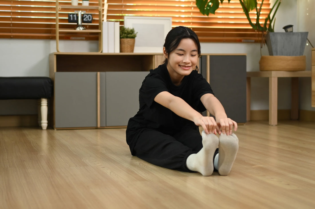 an asian woman stretching her legs on the floor