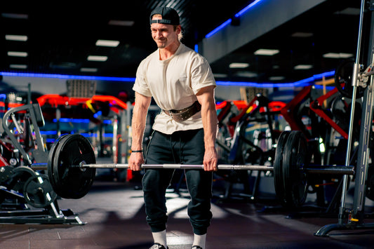 a man deadlifting in a tshirt with blue and red lights in the background