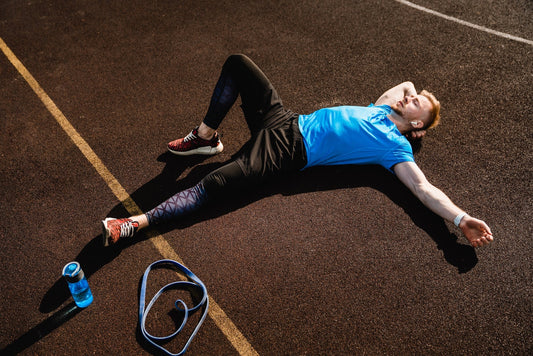 a male athlete laying on the floor resting after training